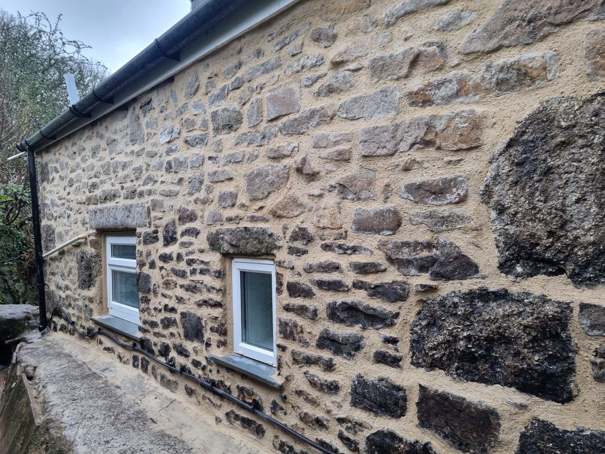 Masonry work carried out on an exterior stone wall at a property in West Cornwall